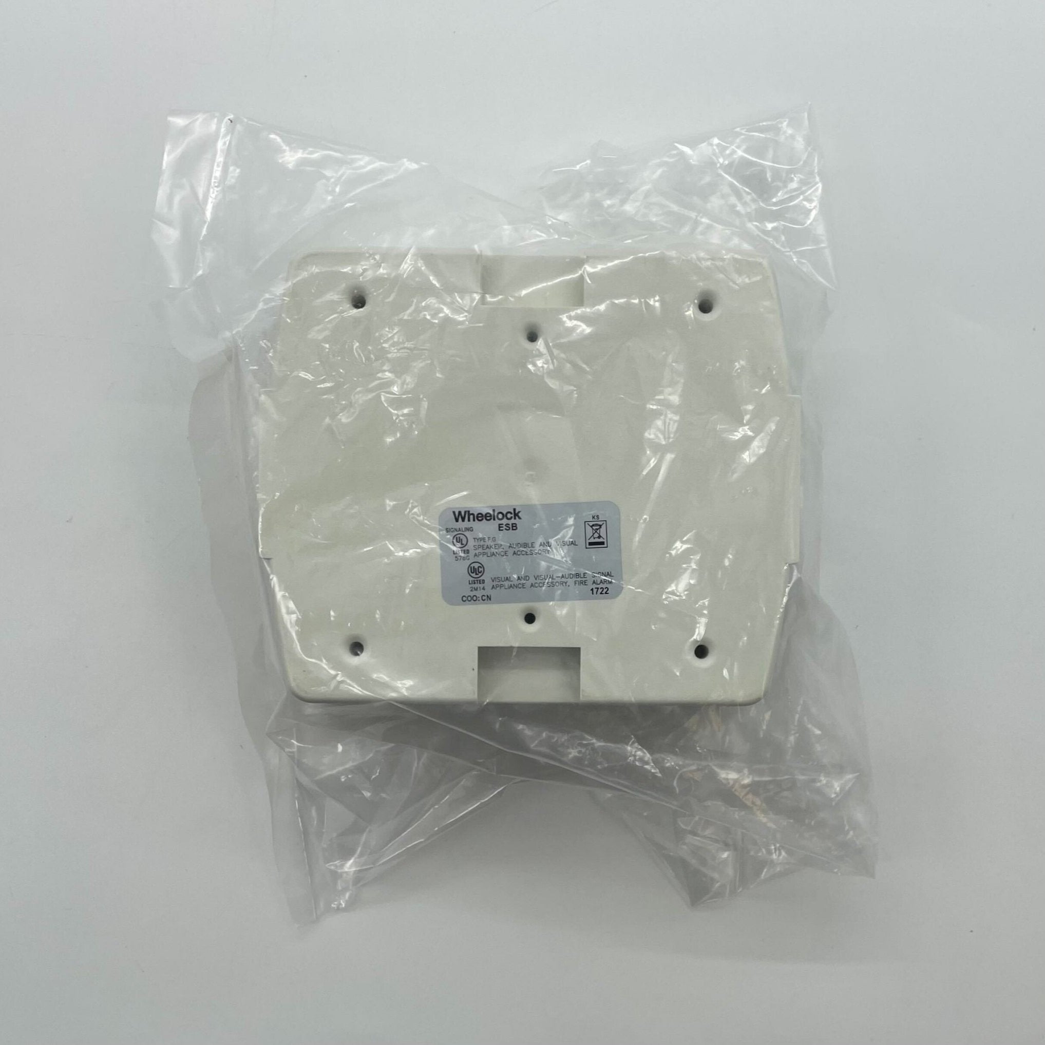 Eaton Wheelock ESBW fire alarm with red alarm bell and mounting bracket, installed on wall for emergency alert system.