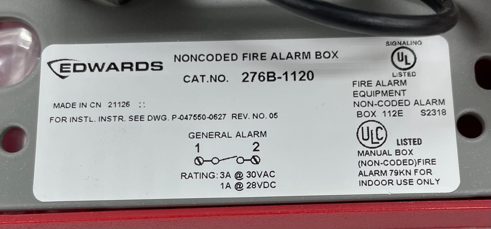 Edwards 276B-1120 pull station mounted on a wall, used for emergency fire alarms, with visible label and metal casing.