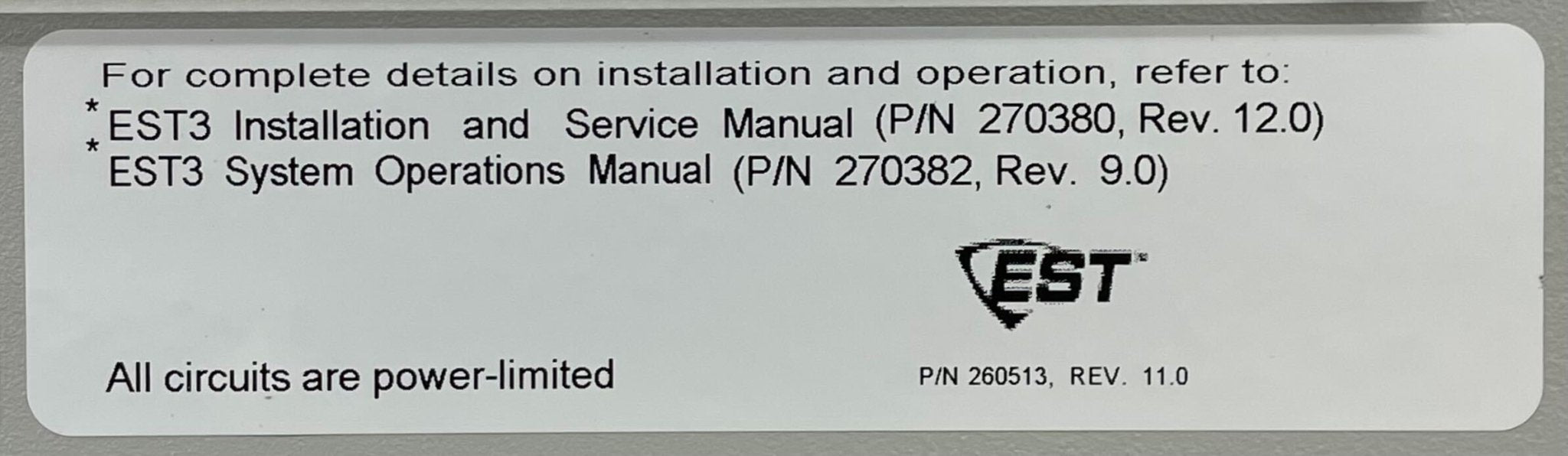 Edwards 3-RLCM/D fire alarm device mounted on wall, black with test and reset buttons, part of Edwards fire alarm system.