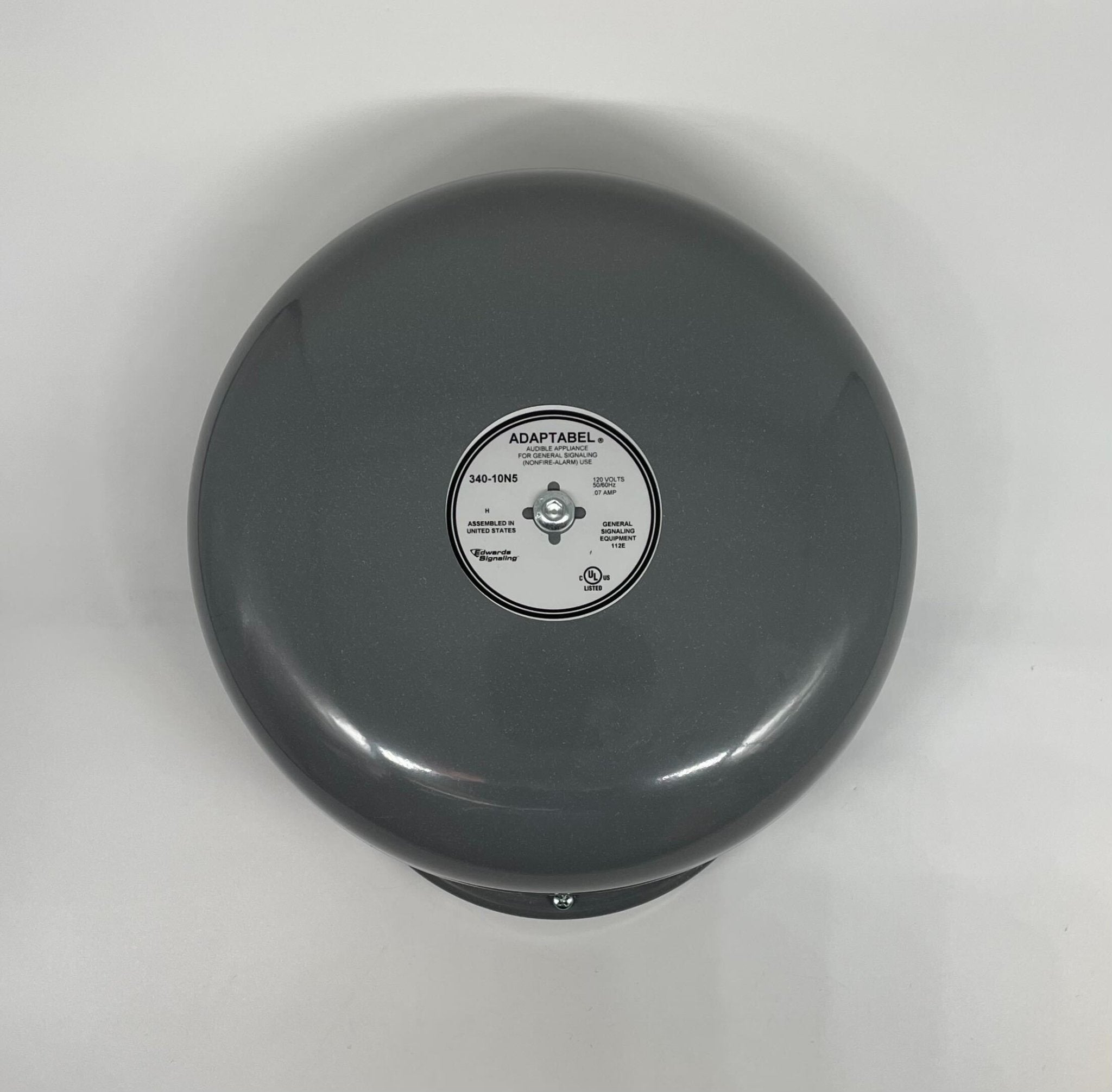 Edwards 340-10N5 brass bell with a polished finish, mounted on a wooden base, used for industrial or emergency signaling.