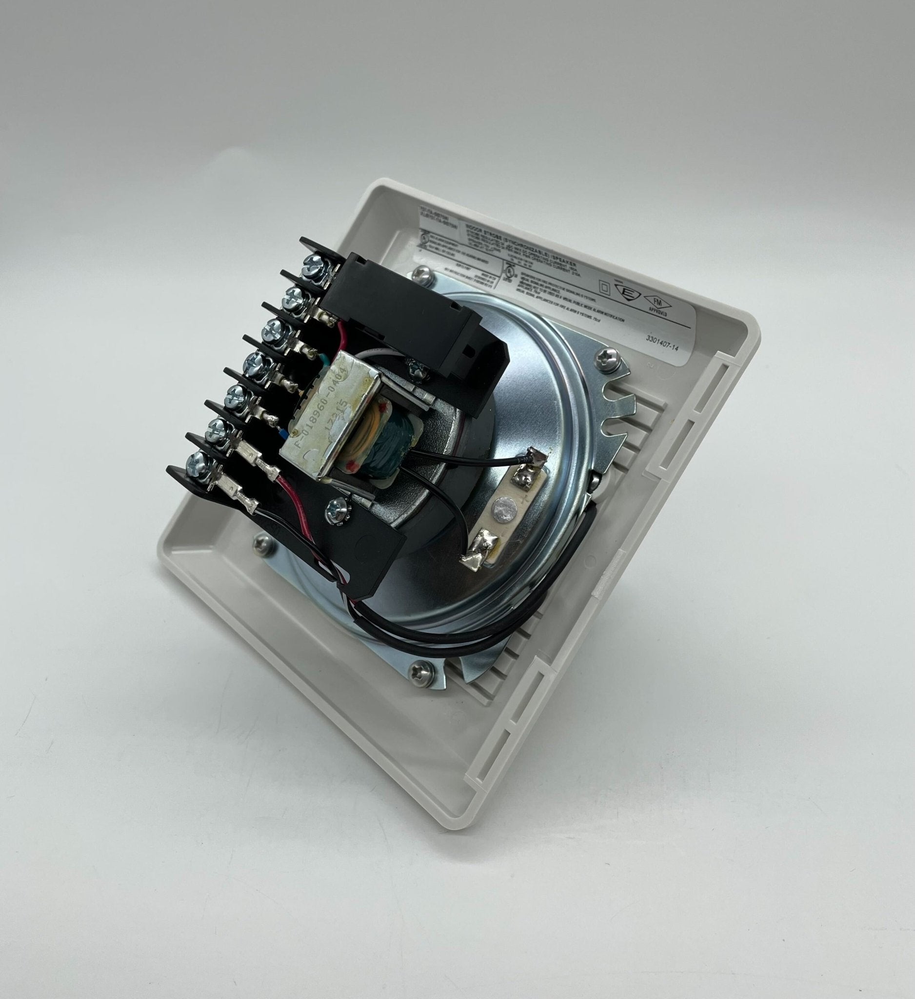 Edwards 757-7A-SS70W speaker strobe light mounted on wall, white safety alarm device with flashing strobe and speaker components.