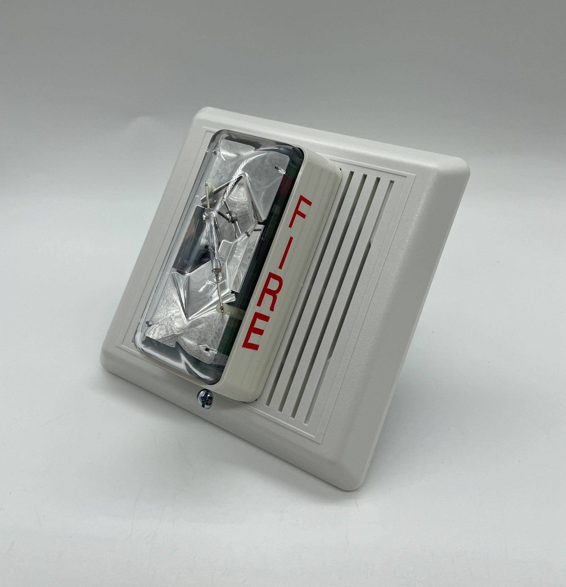 Edwards 757-7A-SS70W speaker strobe light with white face and silver housing, mounted on a wall for fire alarm signaling.