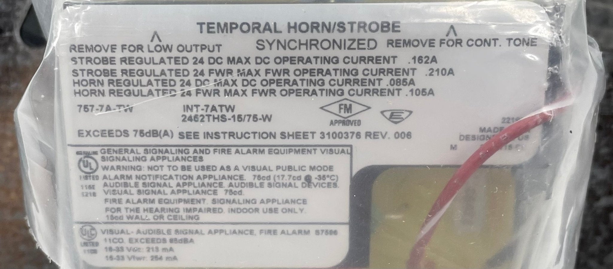 Edwards 757-7A-TW horn strobe warning device with red and white housing, mounted for fire alarm signaling.
