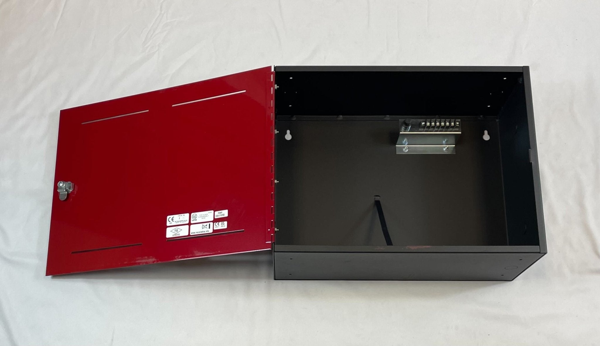 Edwards BC-1R backbox mounted on a wall, featuring a sleek metallic finish and compact design for industrial applications