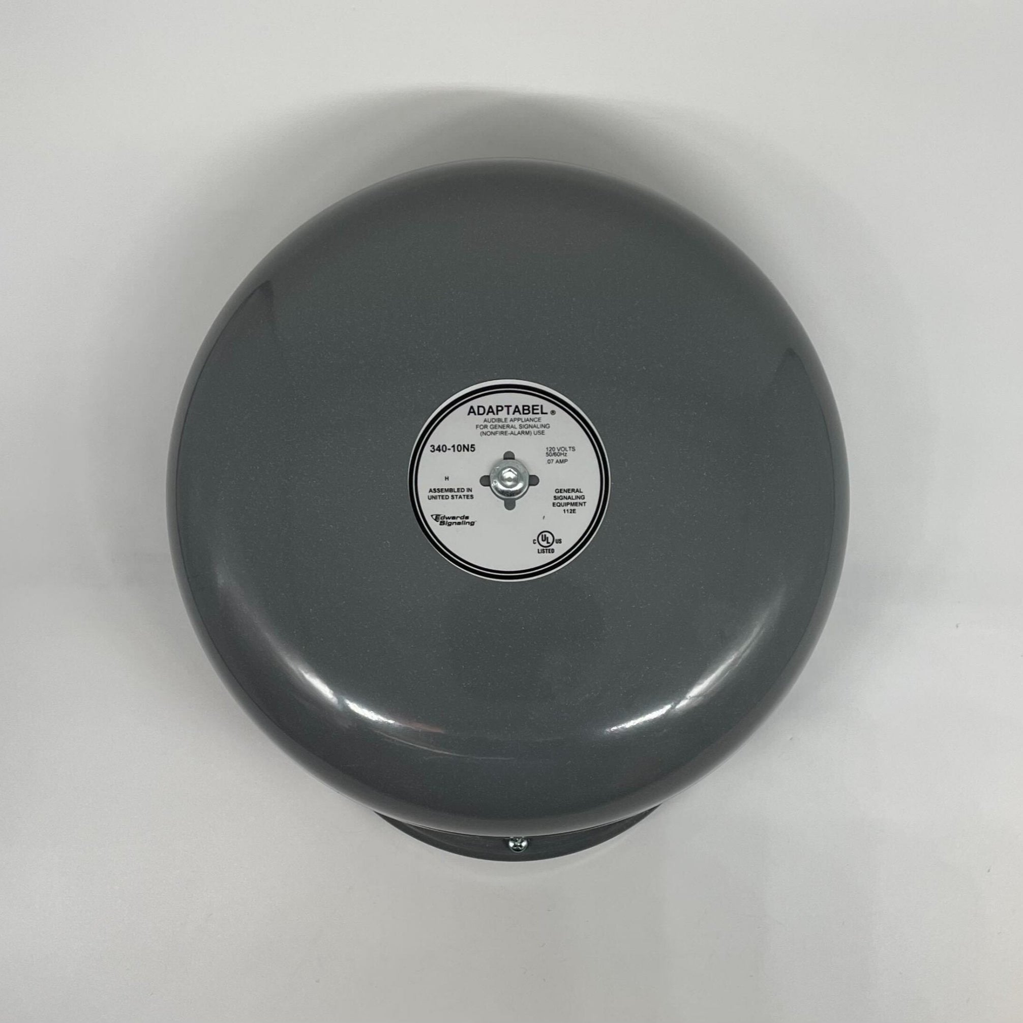 Edwards 340-10N5 brass bell with a polished finish, mounted on a wooden base, used for industrial or emergency signaling.