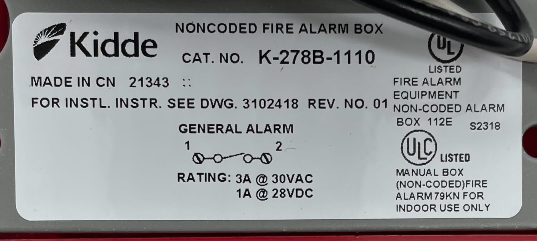 Kidde K-278B-1110 pull station fire alarm switch, black metal safety device with red label and activation lever, mounted on wall.