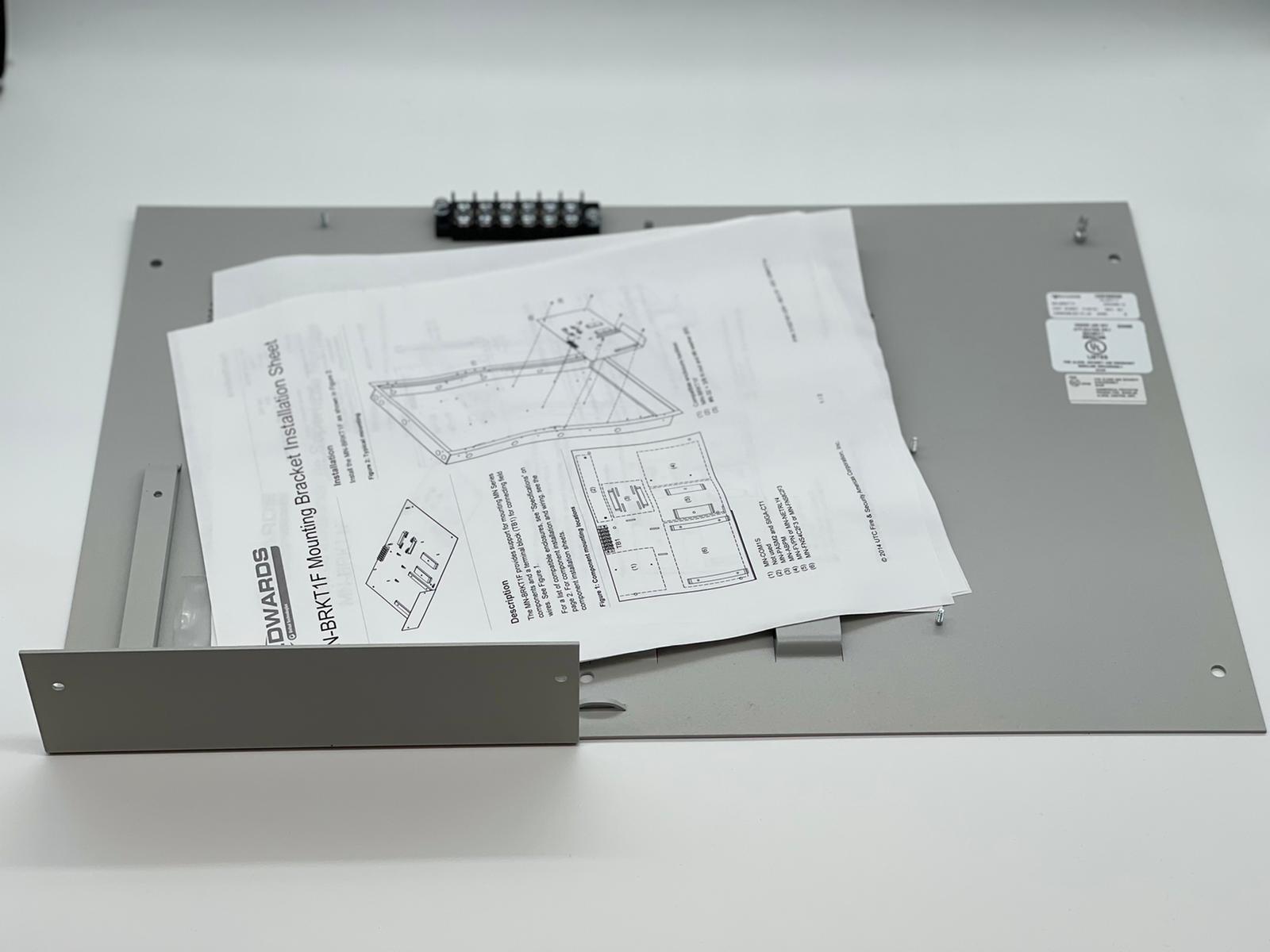 Edwards MN-BRKT1F fire alarm mounting bracket attached to a wall, compatible with Edwards fire alarm systems.