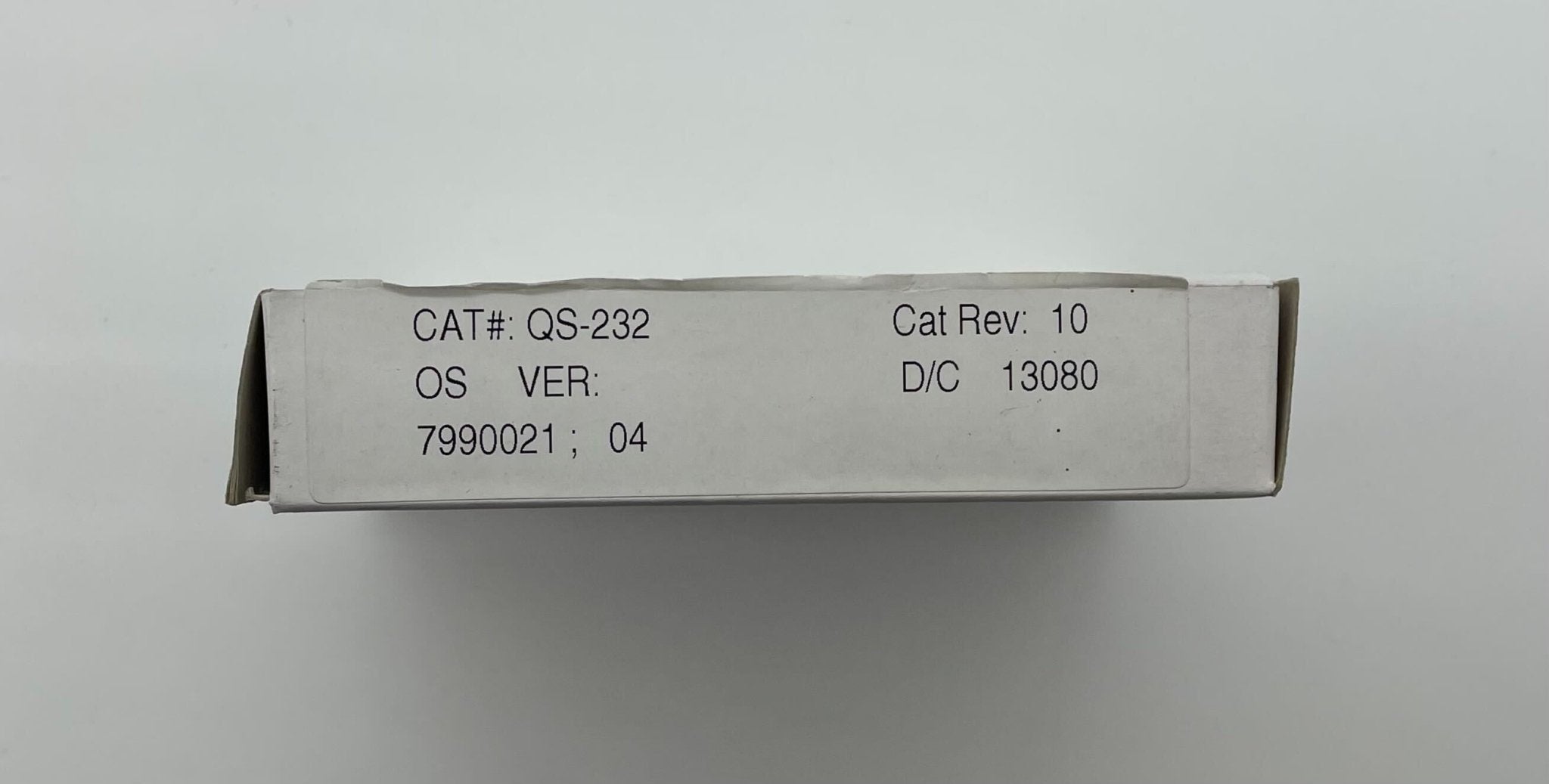 Edwards QS-232 fire alarm with red test/silence button and digital display, mounted on a white wall.