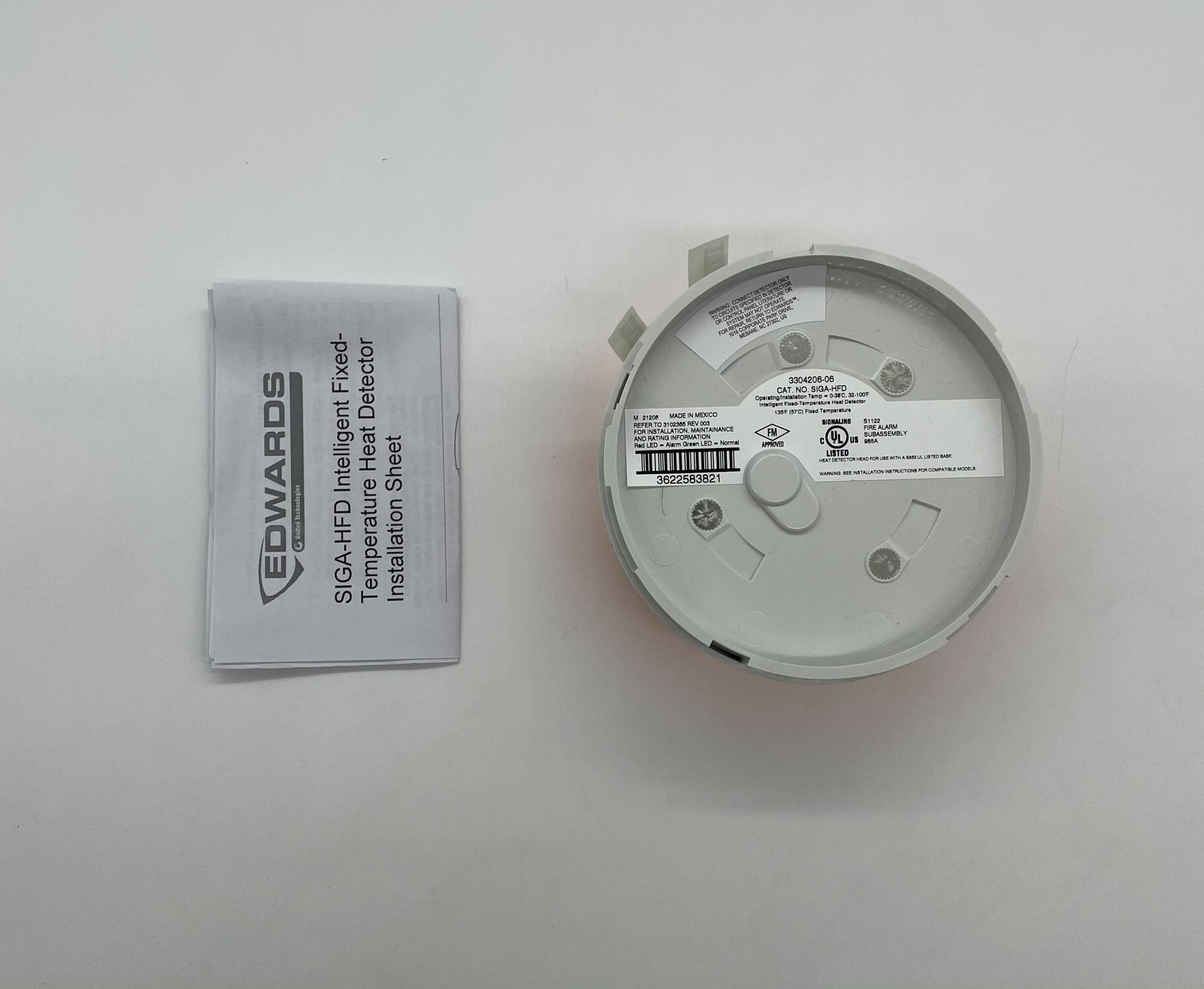 Edwards SIGA-HFD heat detector mounted on ceiling, part of Edwards fire safety system, with wiring and mounting bracket visible.