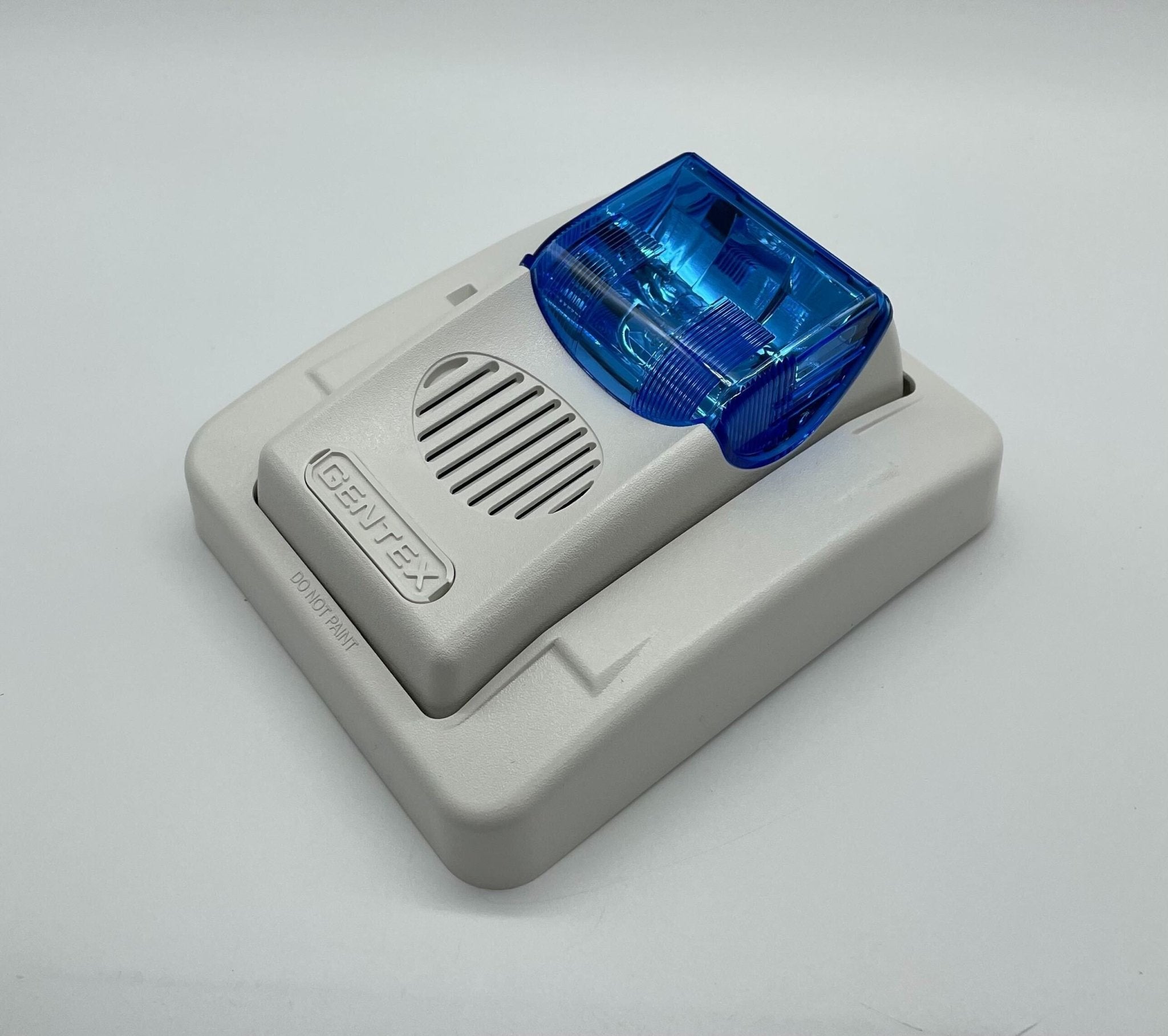 Gentex GECB24PWW horn strobe alarm with white housing, mounted on wall, designed for fire safety and emergency notification.