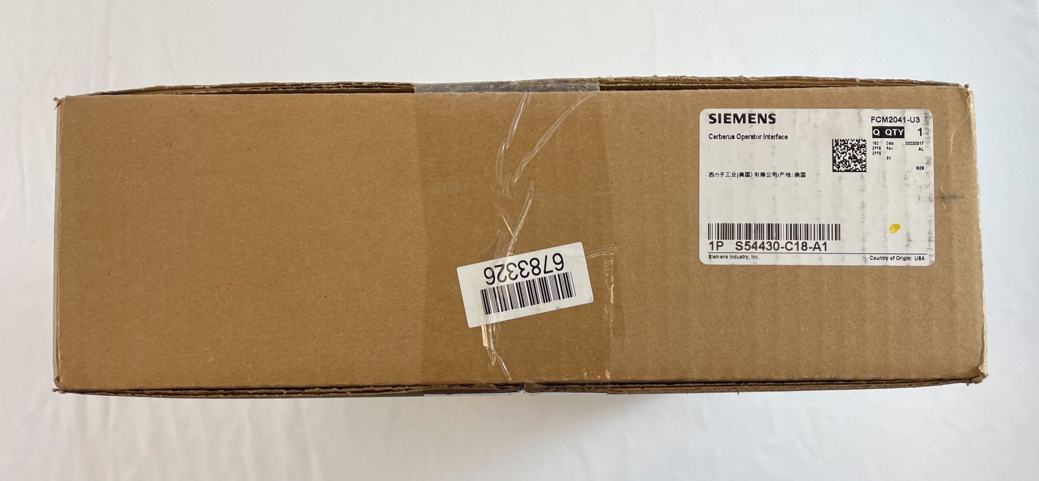 Siemens FCM2041-U3 fire alarm system with digital display and sensor, mounted on a wall in a commercial building.