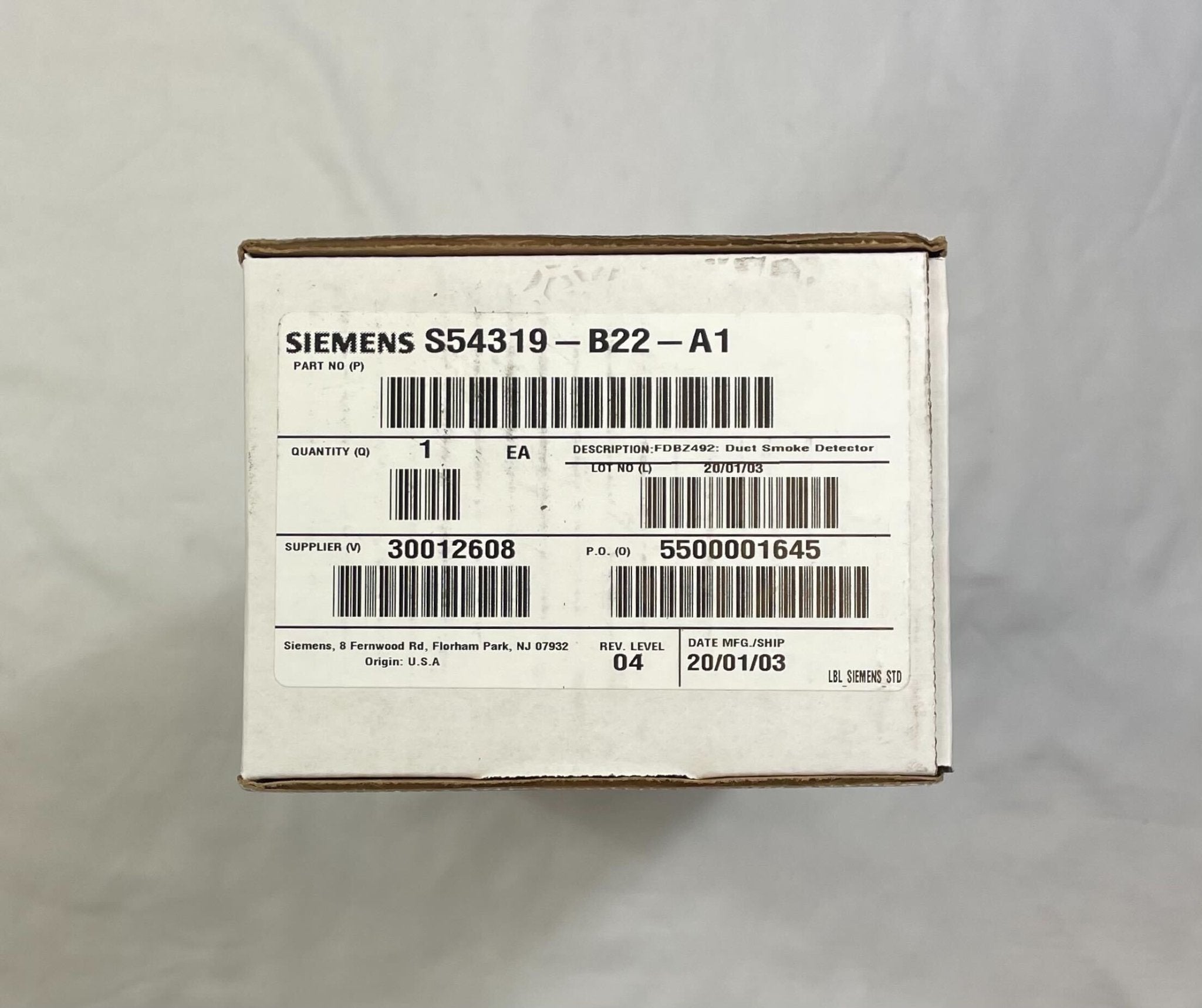 Siemens FDBZ492 duct detector mounted on a wall, featuring electronic components and wiring for HVAC system safety detection.