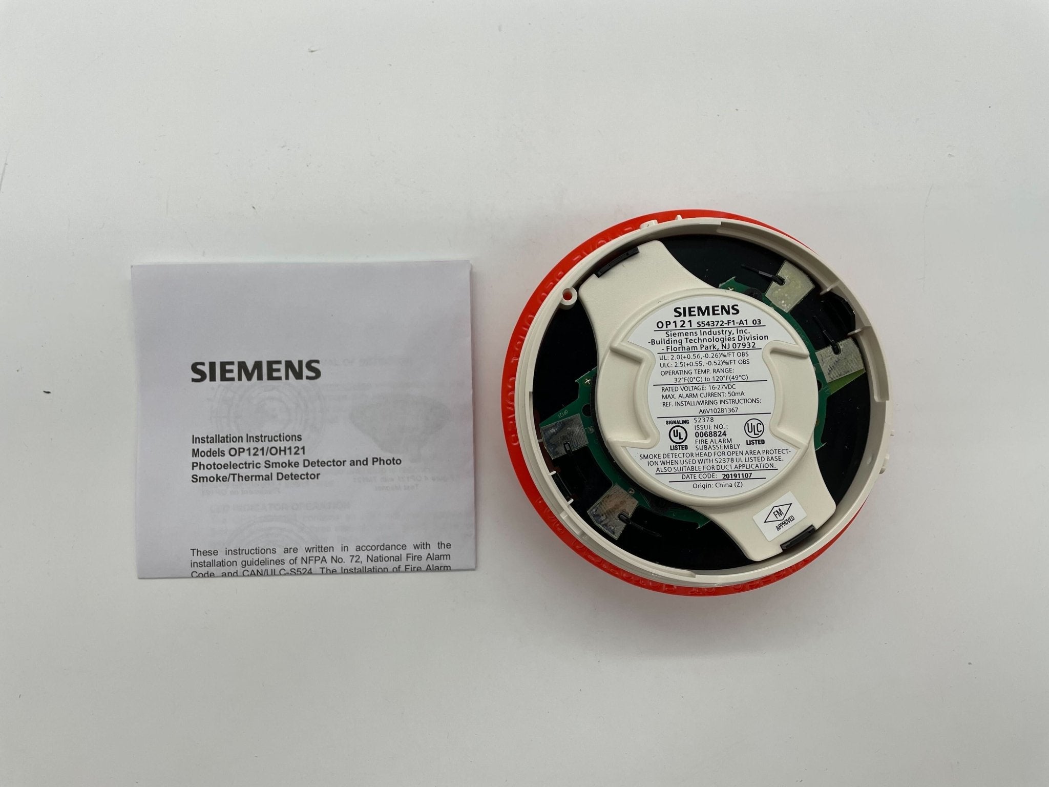 Siemens OP121 smoke detector mounted on ceiling, compact device with alarm indicator for home safety and early fire detection.