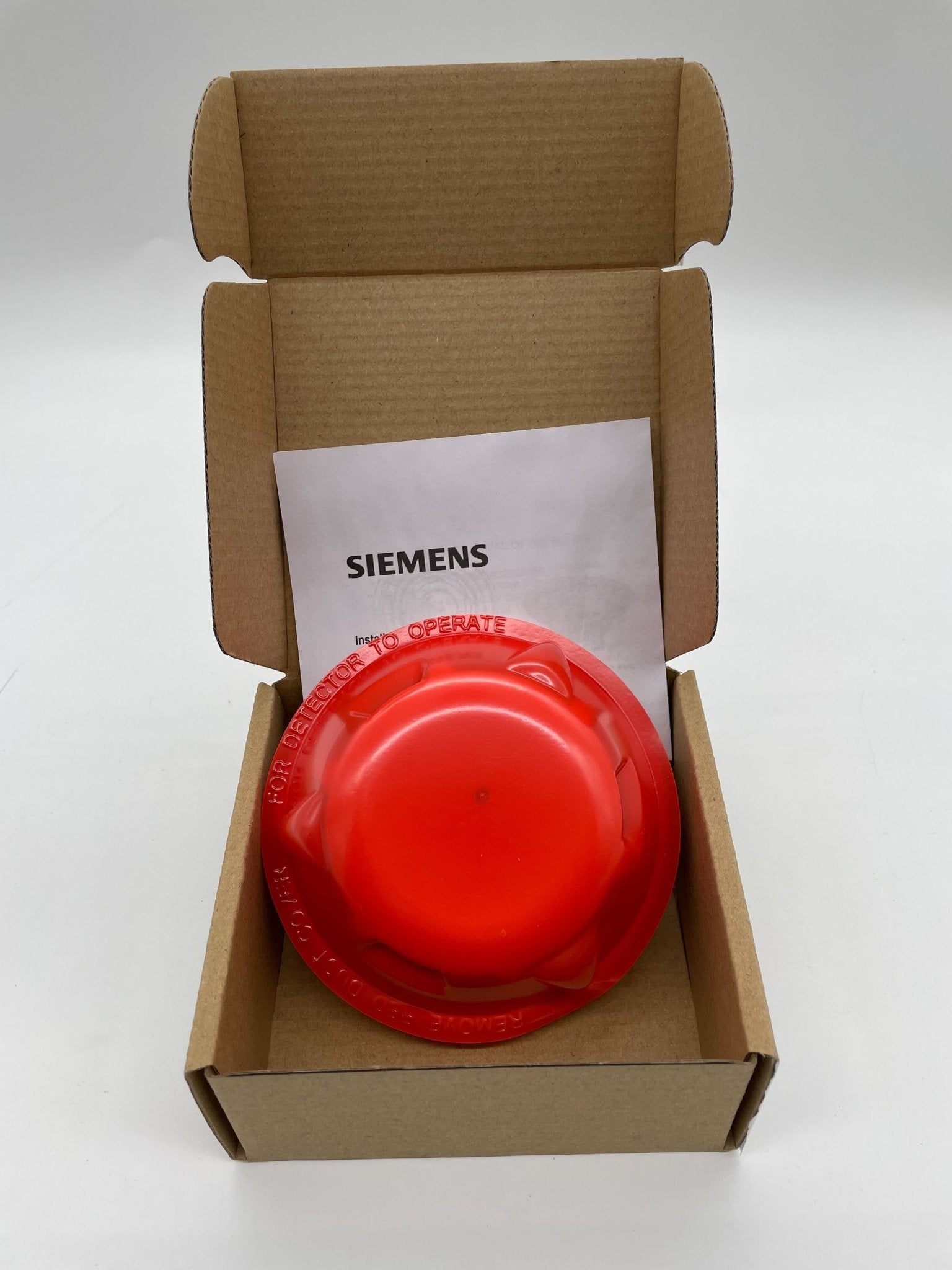 Siemens OP121 smoke detector mounted on ceiling, black sensor with white casing, for residential or commercial fire safety.