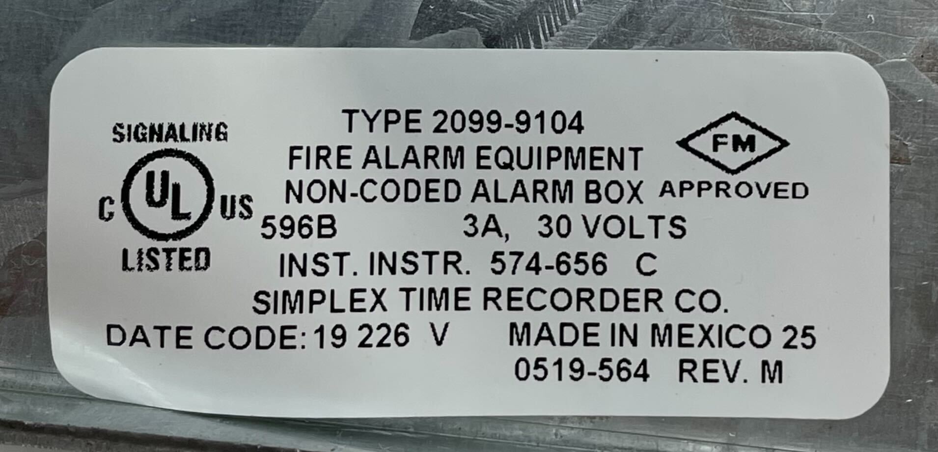 Simplex 2099-9104 pull station with black plastic cover and red label, mounted on a wall for emergency fire alarms.