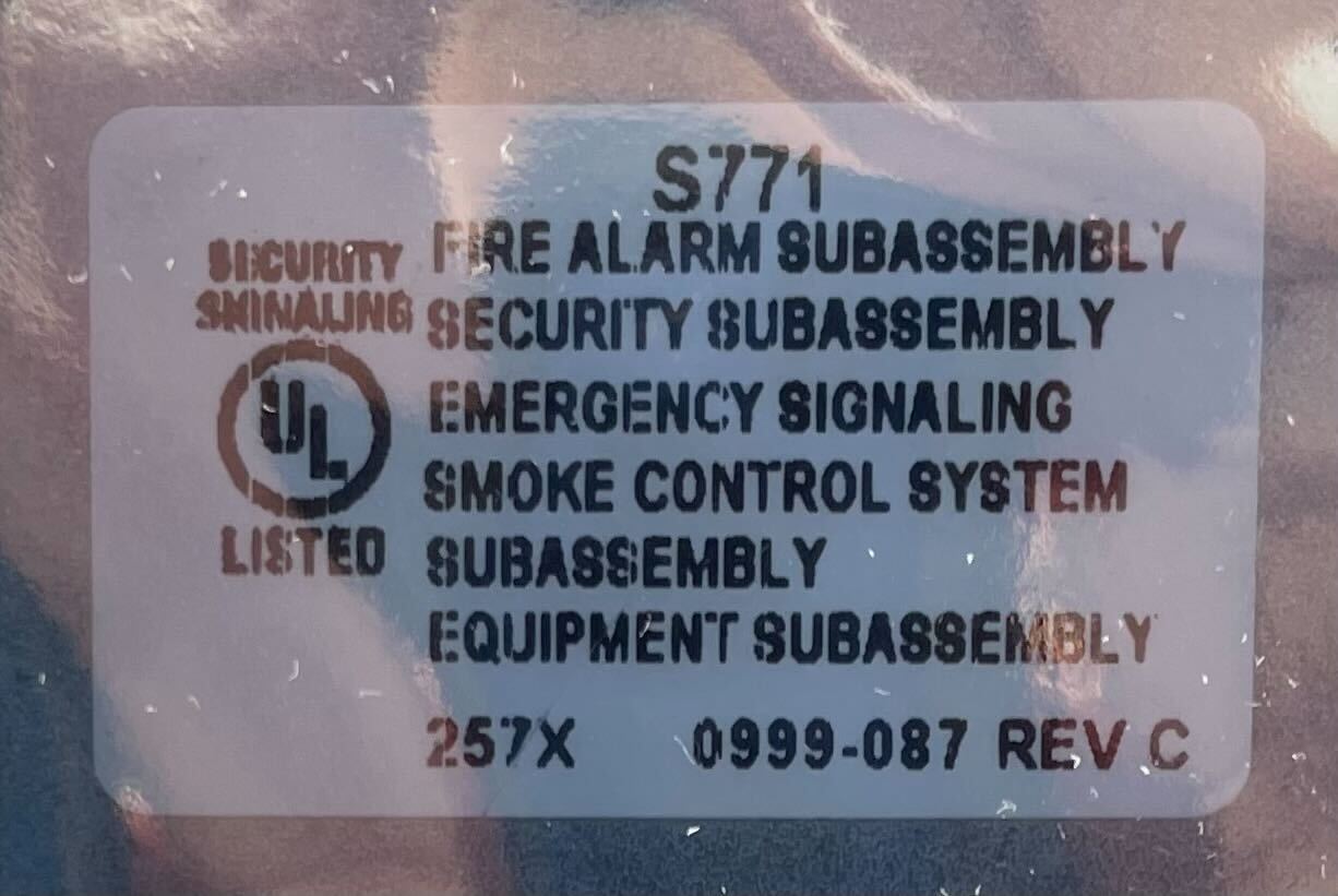 Simplex 4010-9912 fire alarm device with alarm and sensor, mounted on a wall for building safety.