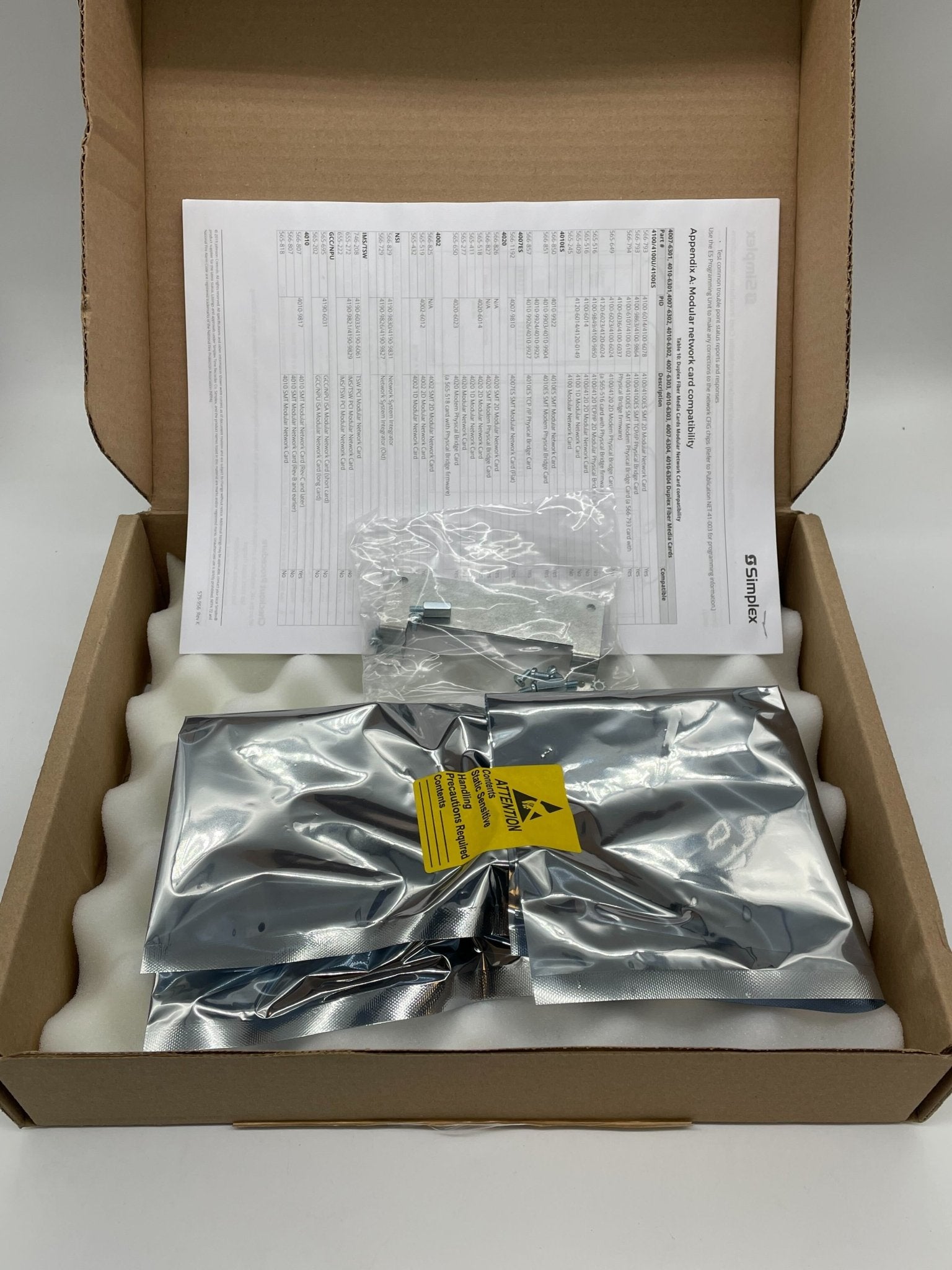 Simplex 4010-9922 fire alarm with white sensor and mounting hardware, designed for building safety and fire detection systems.