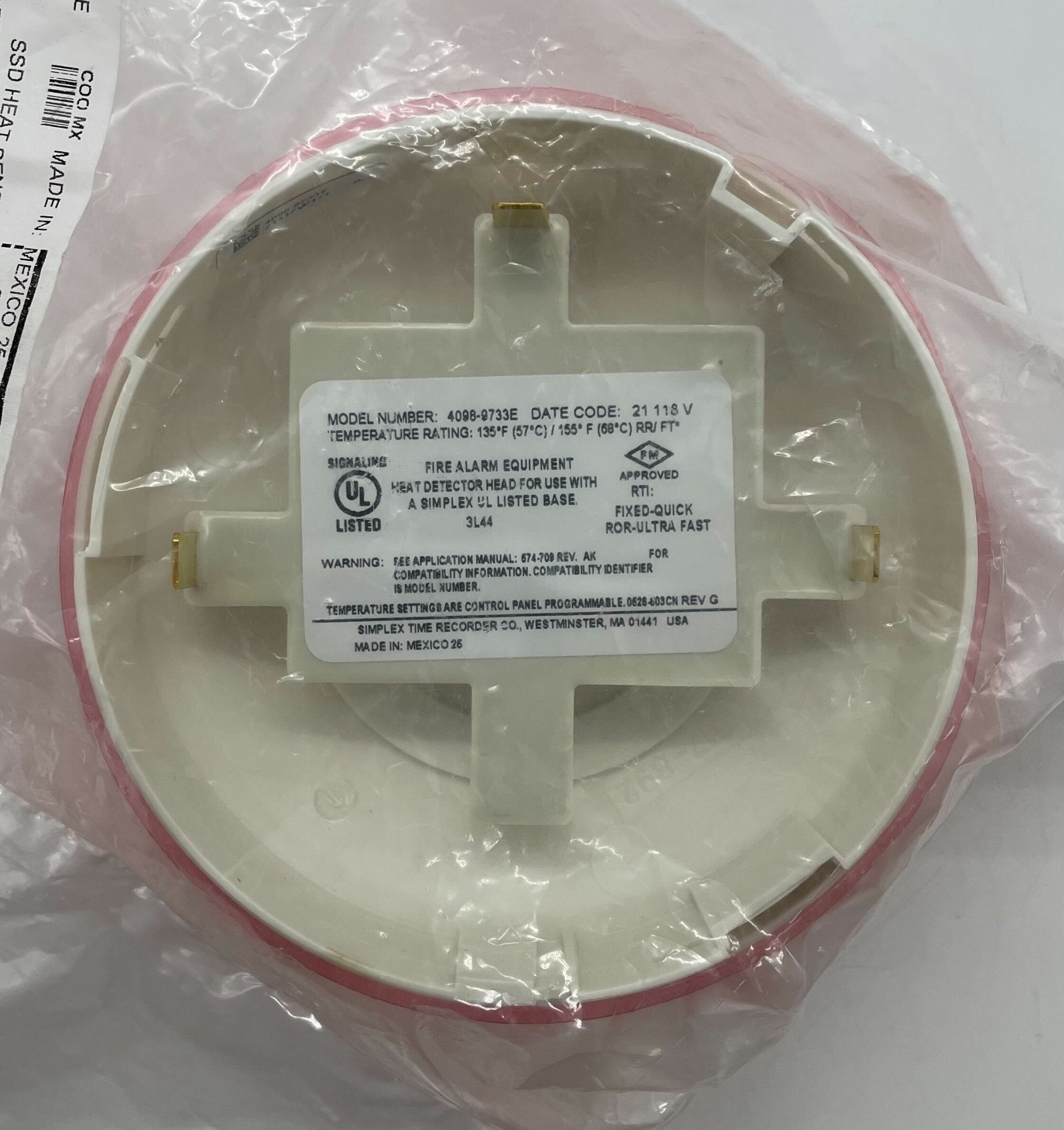 Simplex 4098-9733E heat detector mounted on ceiling, designed for fire safety in commercial or industrial settings.
