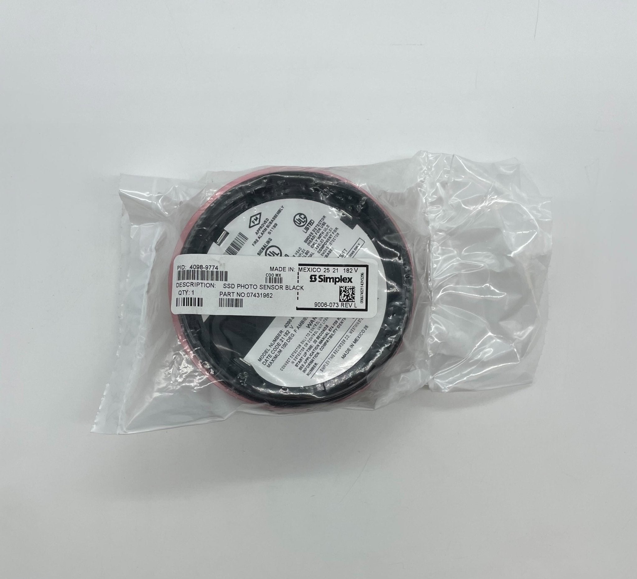 Simplex 4098-9774 smoke detector with white circular design and mounting bracket on a ceiling surface.