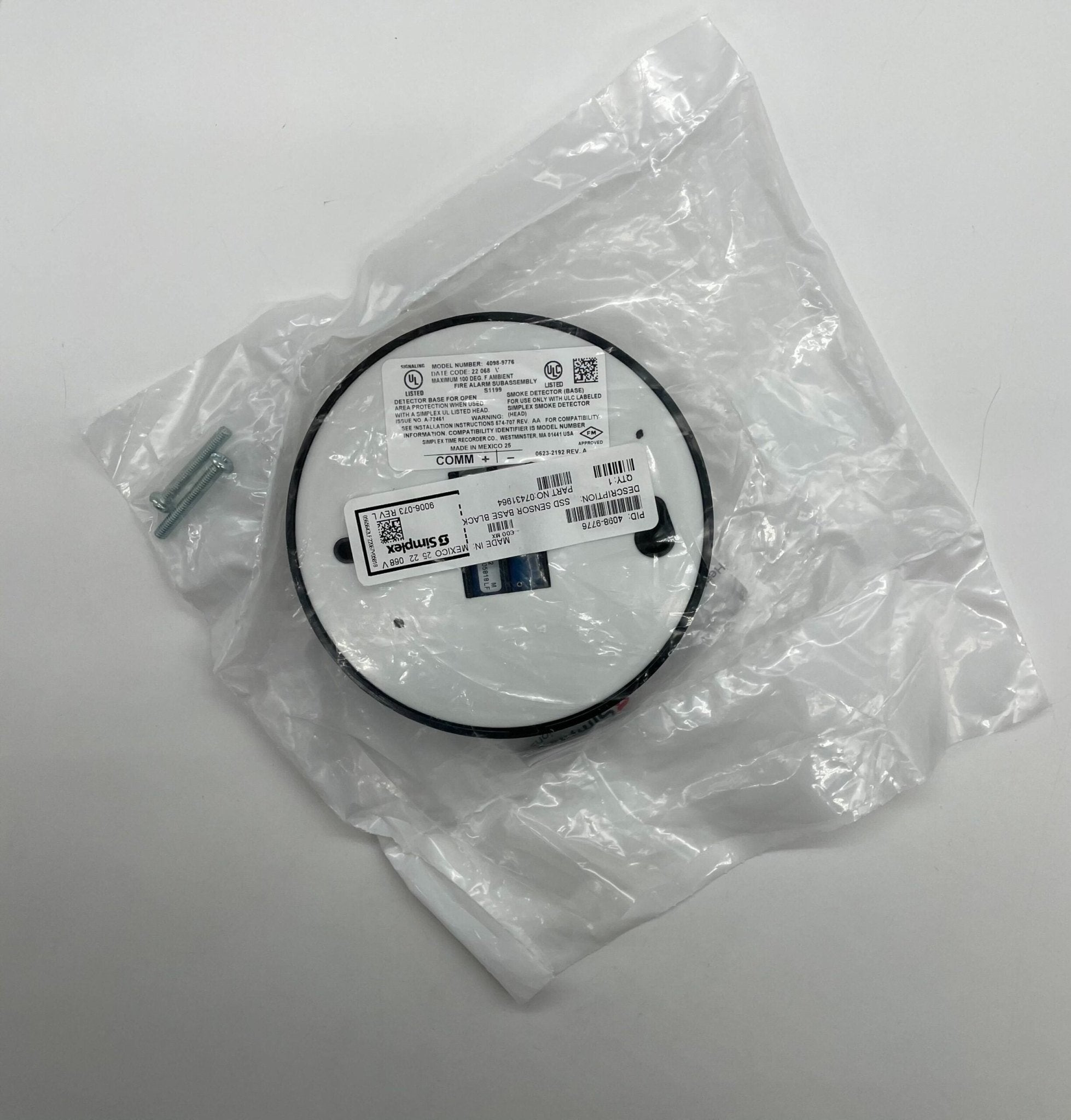 Simplex 4098-9776 smoke detector mounted on ceiling, black and white detector with wiring visible for fire safety systems.