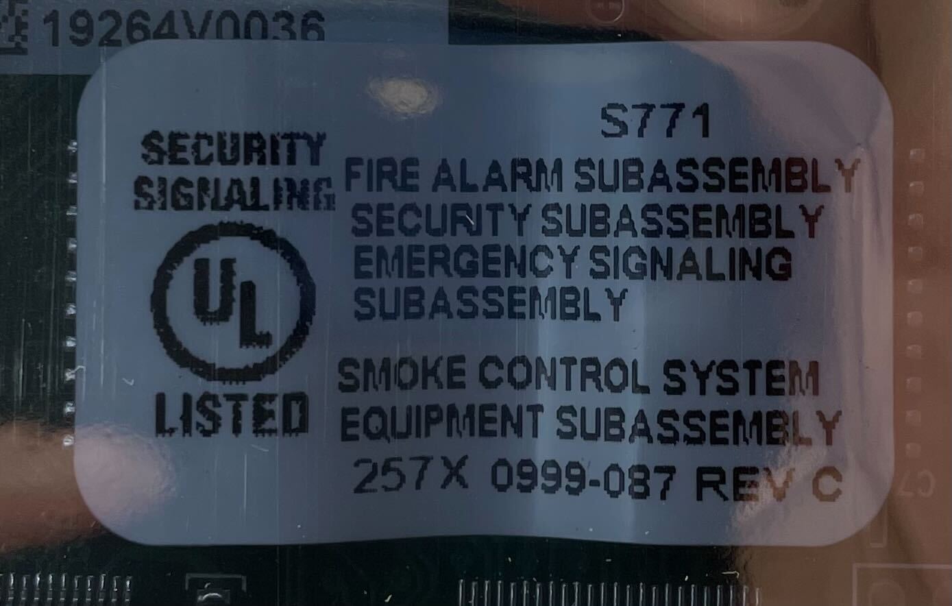 Simplex 4100-0640 fire alarm system mounted on wall, featuring control panel with indicator lights and alarm buttons.