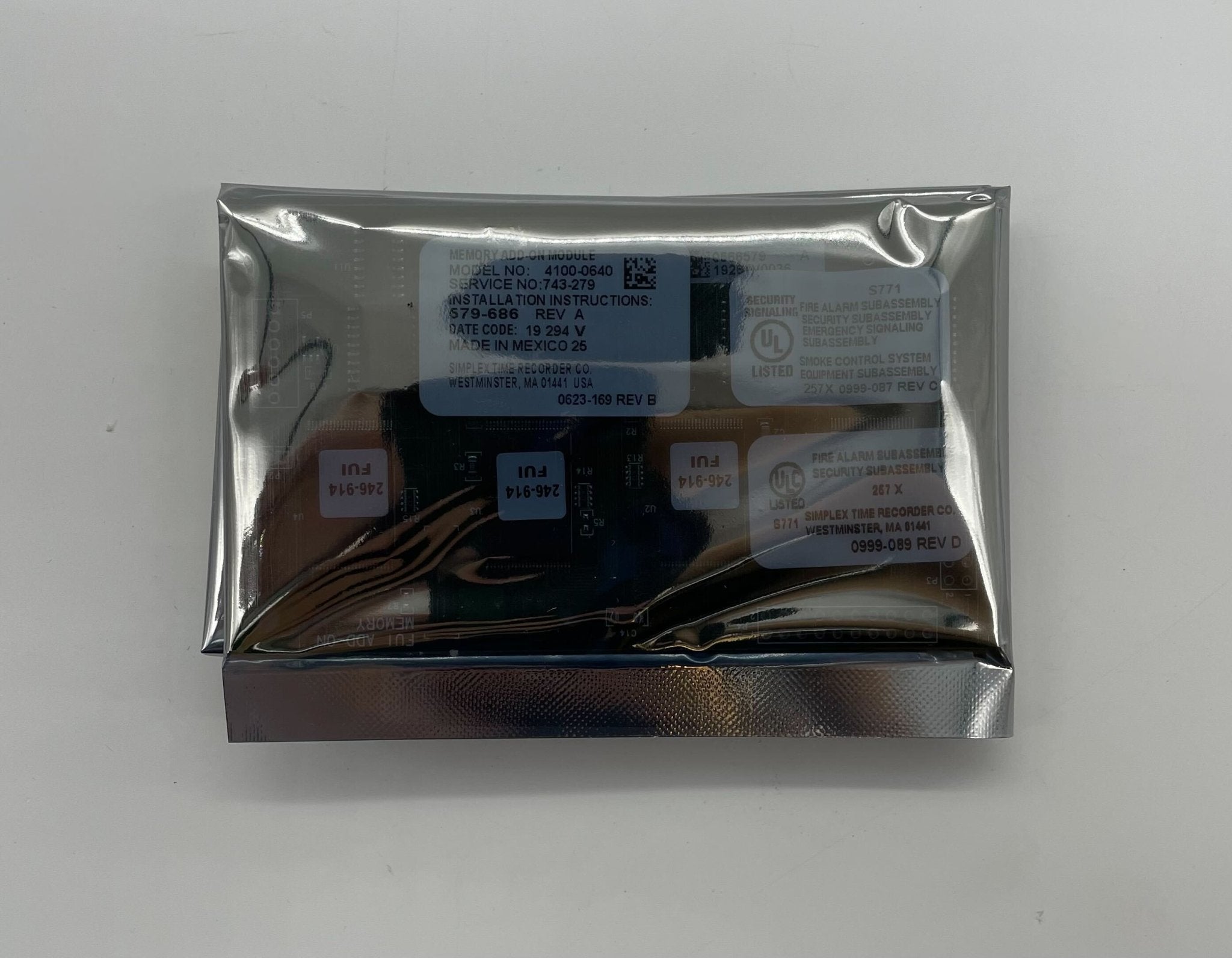 Simplex 4100-0640 fire alarm device with white casing, part of Simplex fire alarm system, mounted on a wall.