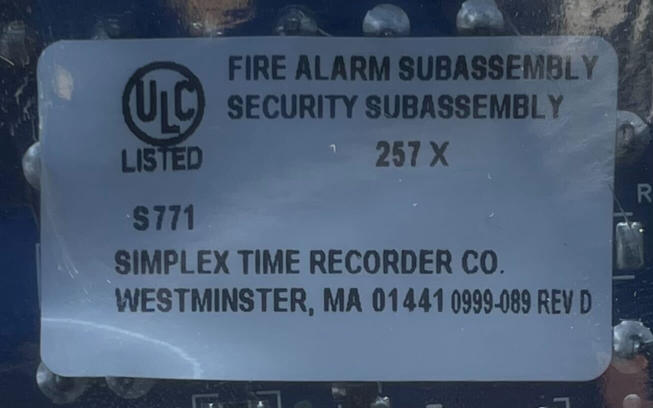 Simplex 4100-1245 fire alarm system with control panel, featuring alert indicators and wiring components.