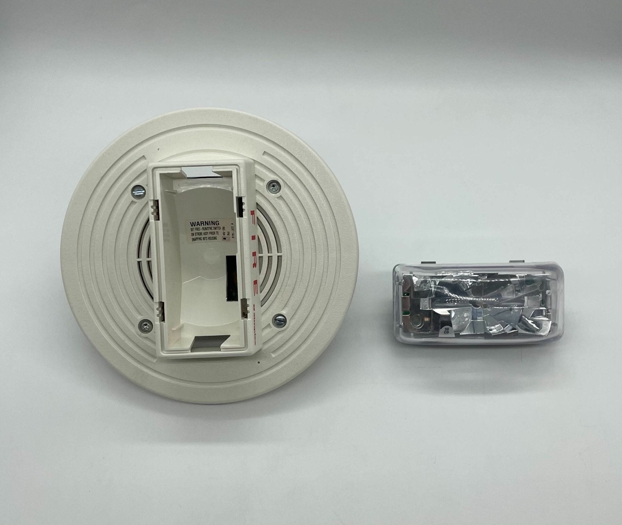 Simplex 4903-9197 fire alarm with white plastic housing and mounting bracket for commercial safety systems.