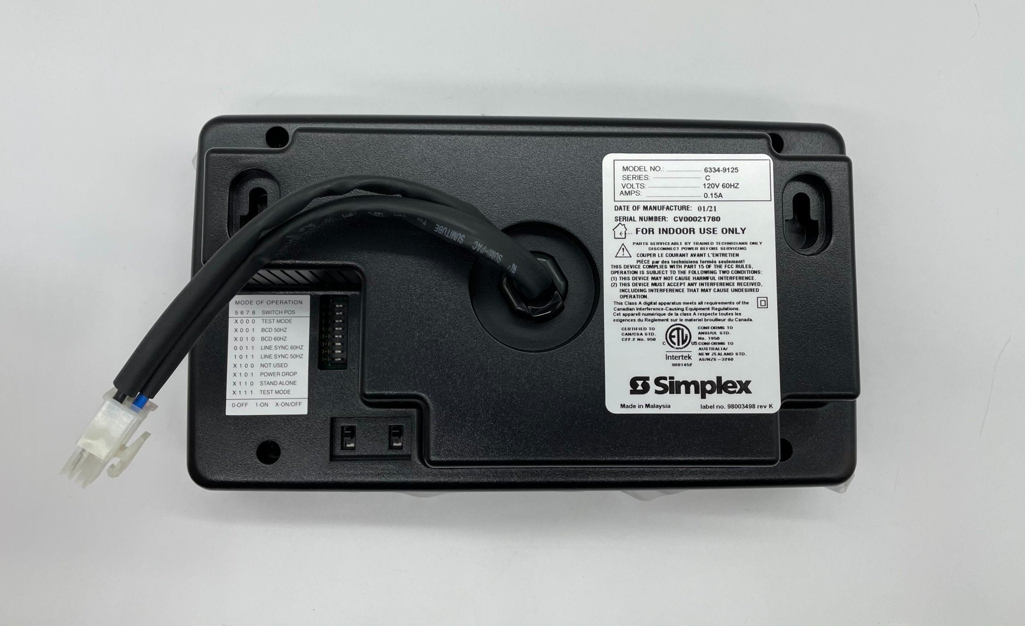 Simplex 6334-9125 fire alarm from Simplex, mounted on a wall, with a white circular design and indicator light.