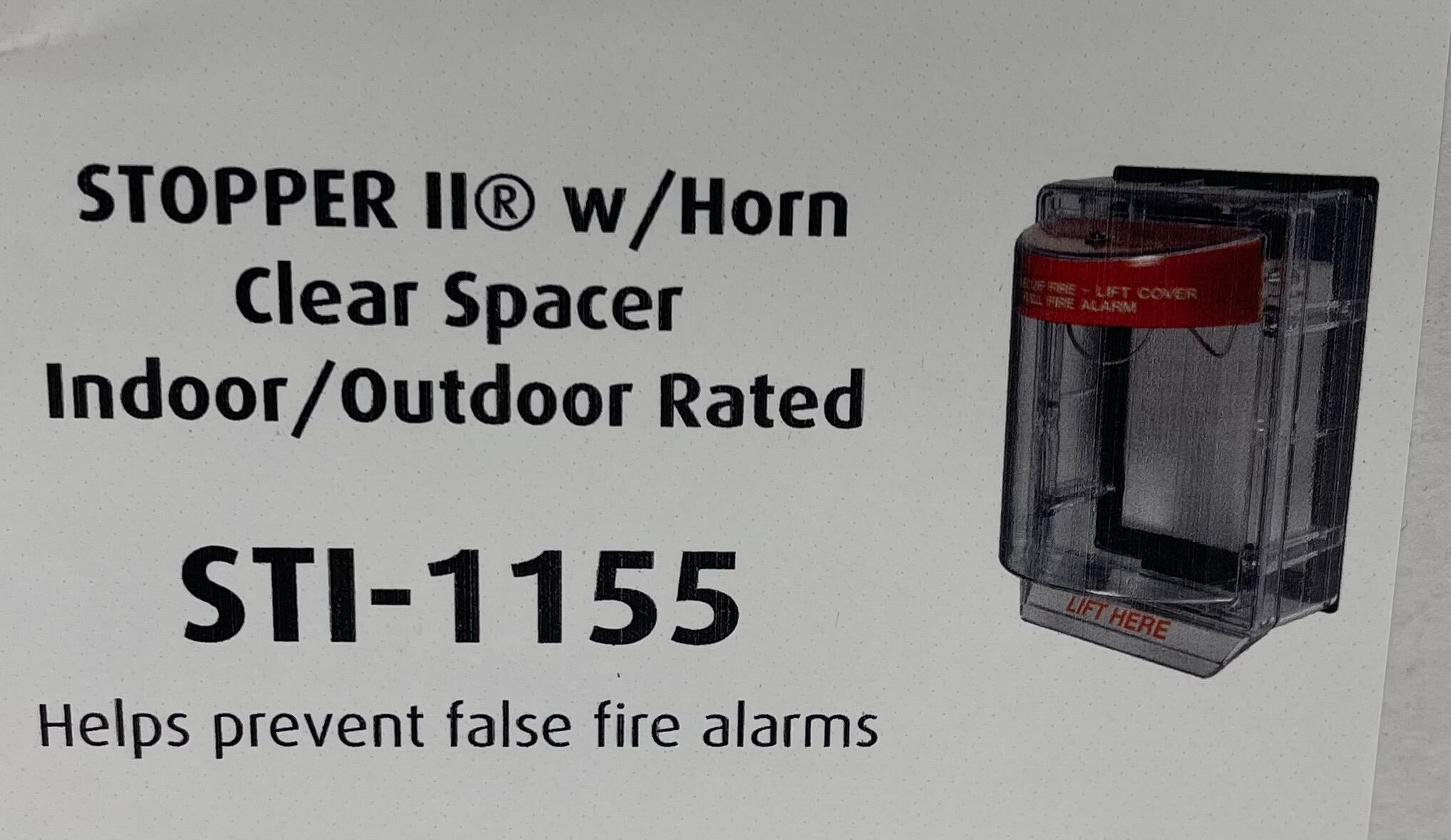 STI-1155 clear polycarbonate pull station with emergency release handle, mounted on wall for fire safety and alarm activation.