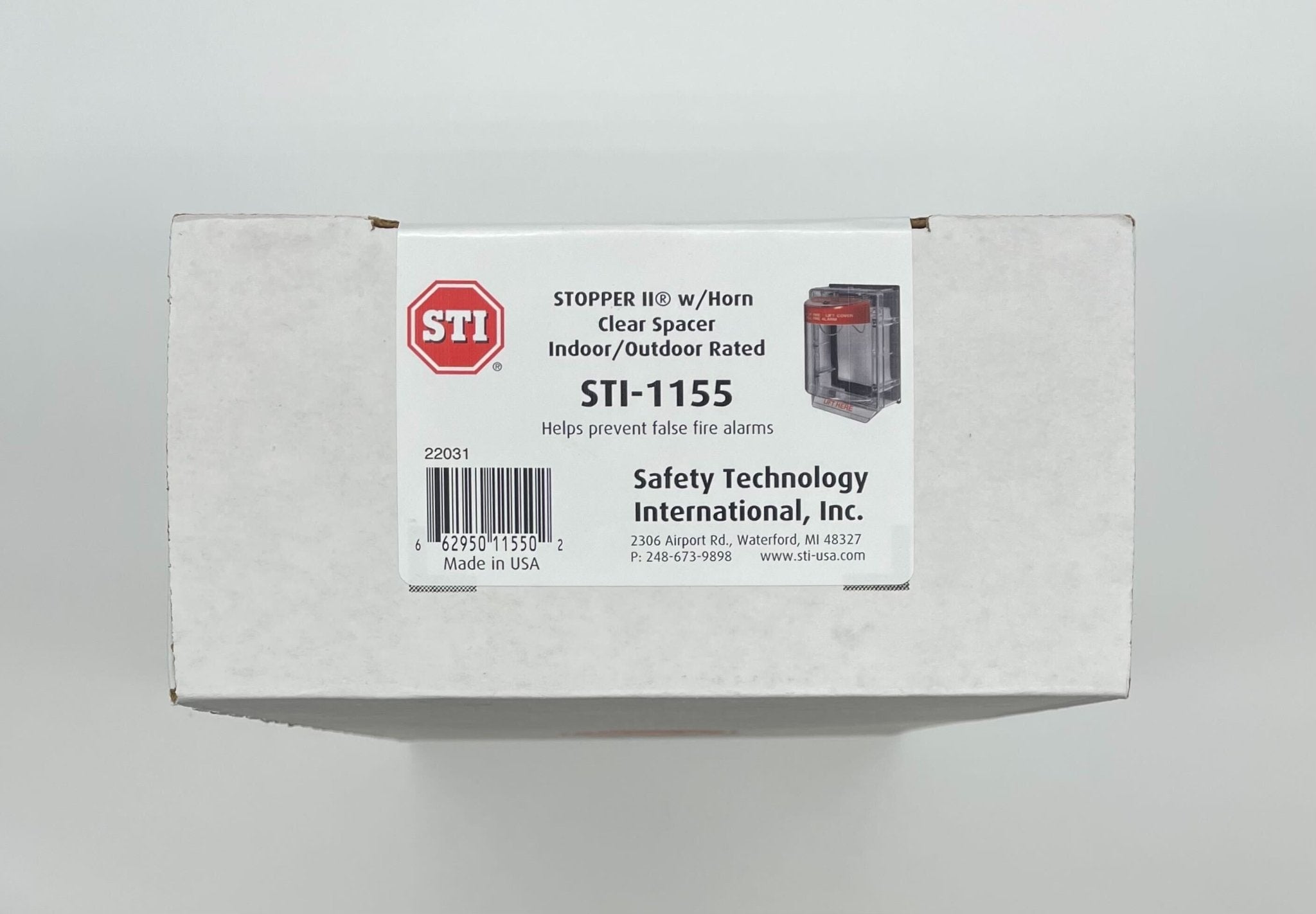 STI-1155 clear polycarbonate pull station for emergency alarms, mounted on wall with visible red label and pull handle.