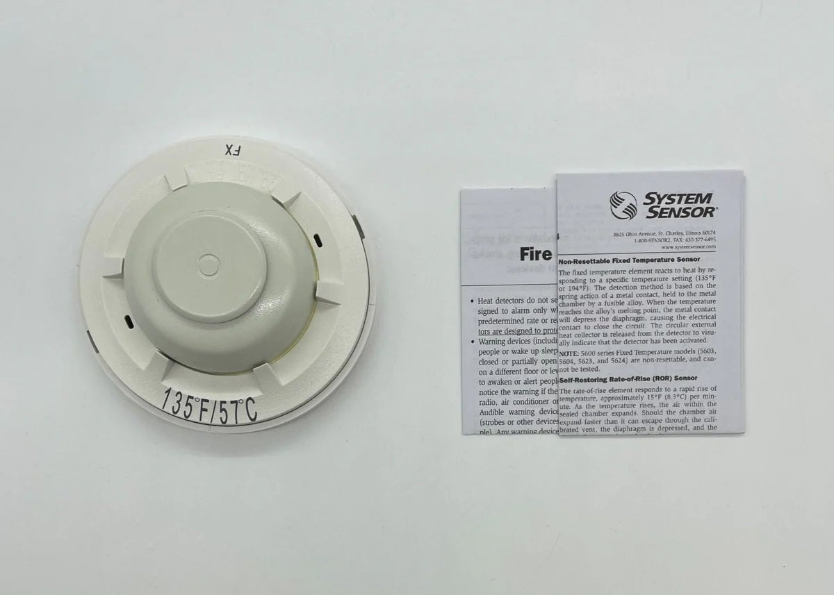 System Sensor 5603 fire alarm smoke detector with test and reset buttons, white plastic housing, mounted on ceiling.