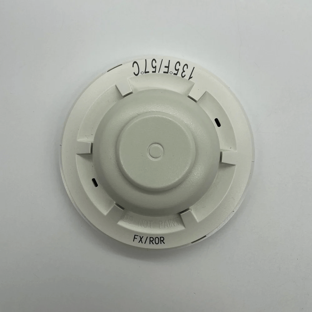 System Sensor 5621 smoke detector mounted on ceiling, featuring a white alarm unit with electronic sensors for fire detection.