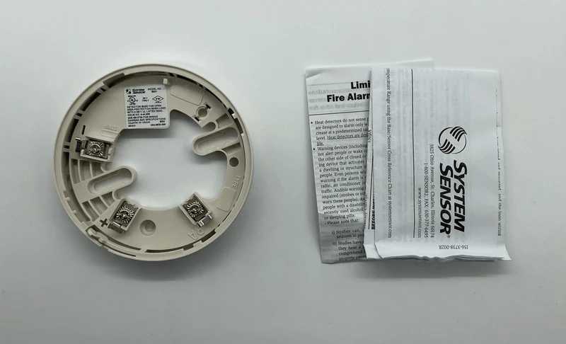 System Sensor B501BP fire alarm sensor with Jem Systems Canada branding, featuring a round white detector with mounting base.
