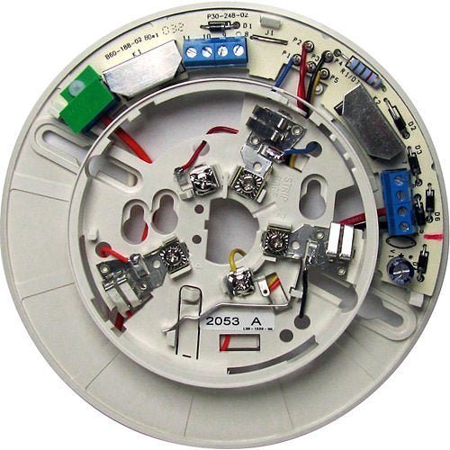 System Sensor B114LPBT smoke detector with long-life battery and tamper-proof design, mounted on wall inside a building.