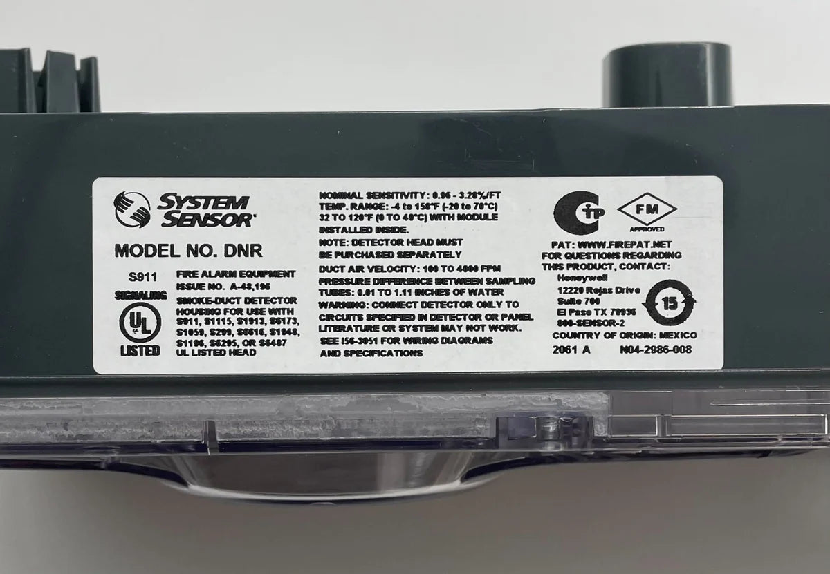 System Sensor DNR smoke detector with sleek design, mounted on ceiling, featuring sensor and wiring for fire safety.