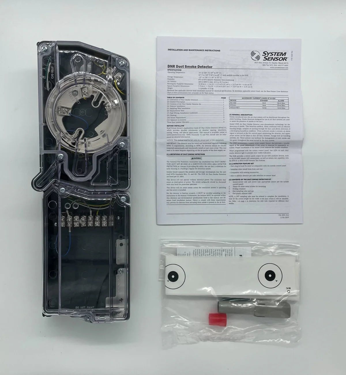 System Sensor DNR fire alarm detector mounted on ceiling, featuring a white sensor cover and electrical wiring for fire safety.