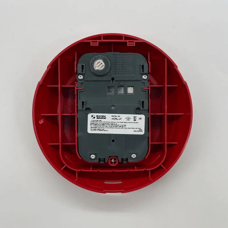 System Sensor HCRL-LF fire alarm relay module mounted on a panel, with wiring and connection terminals visible.