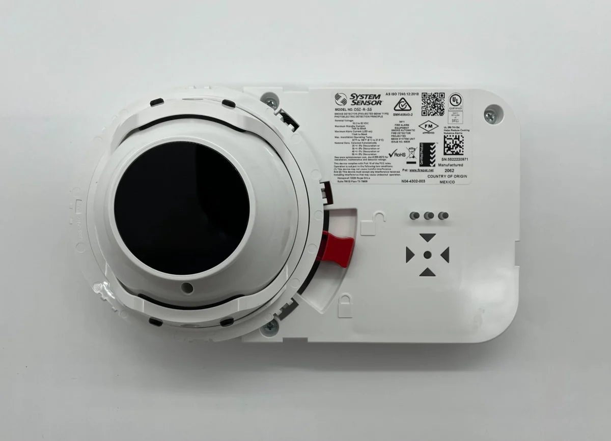 System Sensor OSI-R-SS smoke detector mounted on ceiling, with wiring and mounting hardware visible.