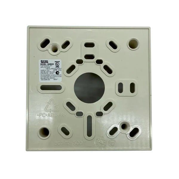 System Sensor SMB500 US smoke detector with alarm and sensor components, mounted on a ceiling in a typical installation setting.