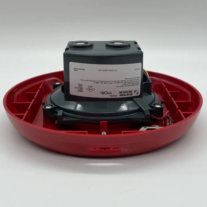 System Sensor SPCRL fire alarm relay module with wiring and mounting components on a neutral background.