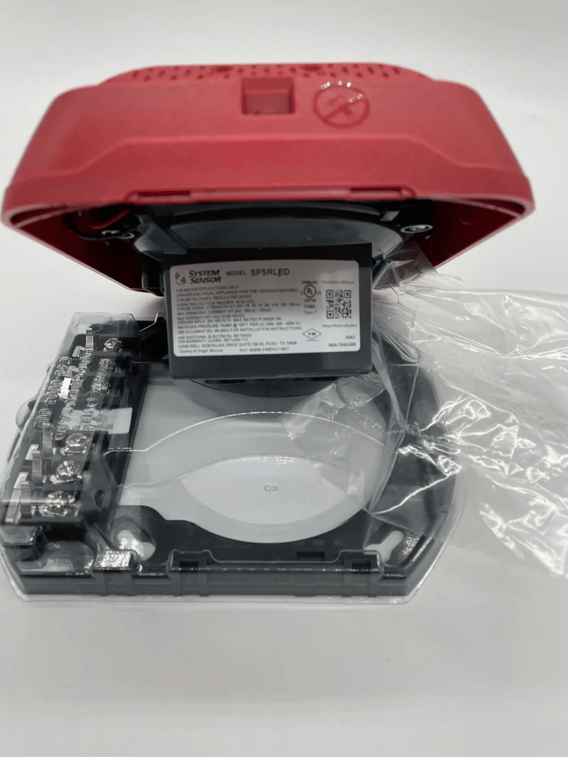 System Sensor SPSRLED LED strobe light with red lens for fire alarm signaling, mounted on a white background.