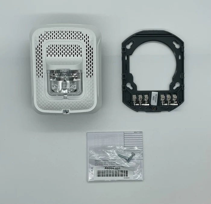 System Sensor SPSWL-P fire alarm sensor with white plastic cover, mounted on wall for fire detection and safety.