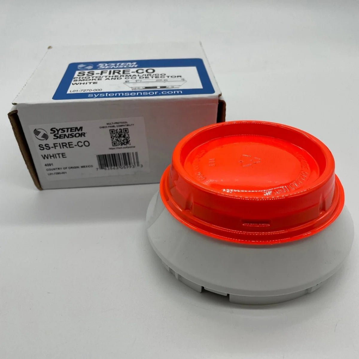 System Sensor SS-FIRE-CO smoke and fire detector with alarm, mounted on ceiling in a modern building interior.