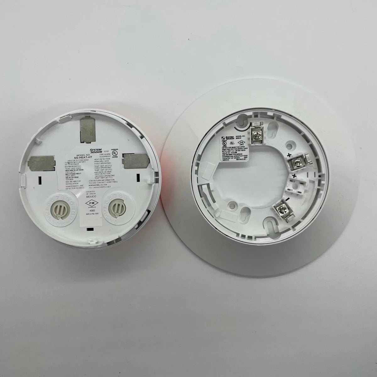 System Sensor SS-HEAT-HT heat detector with mounting base, designed for fire alarm systems, shown in a close-up view.