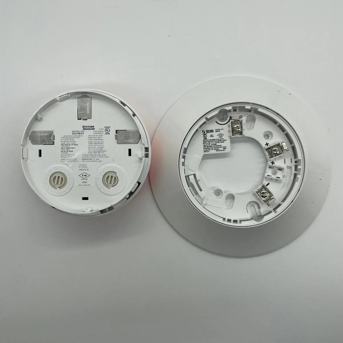 System Sensor SS-HEAT heat sensor with mounting bracket and wiring connections for fire alarm systems.
