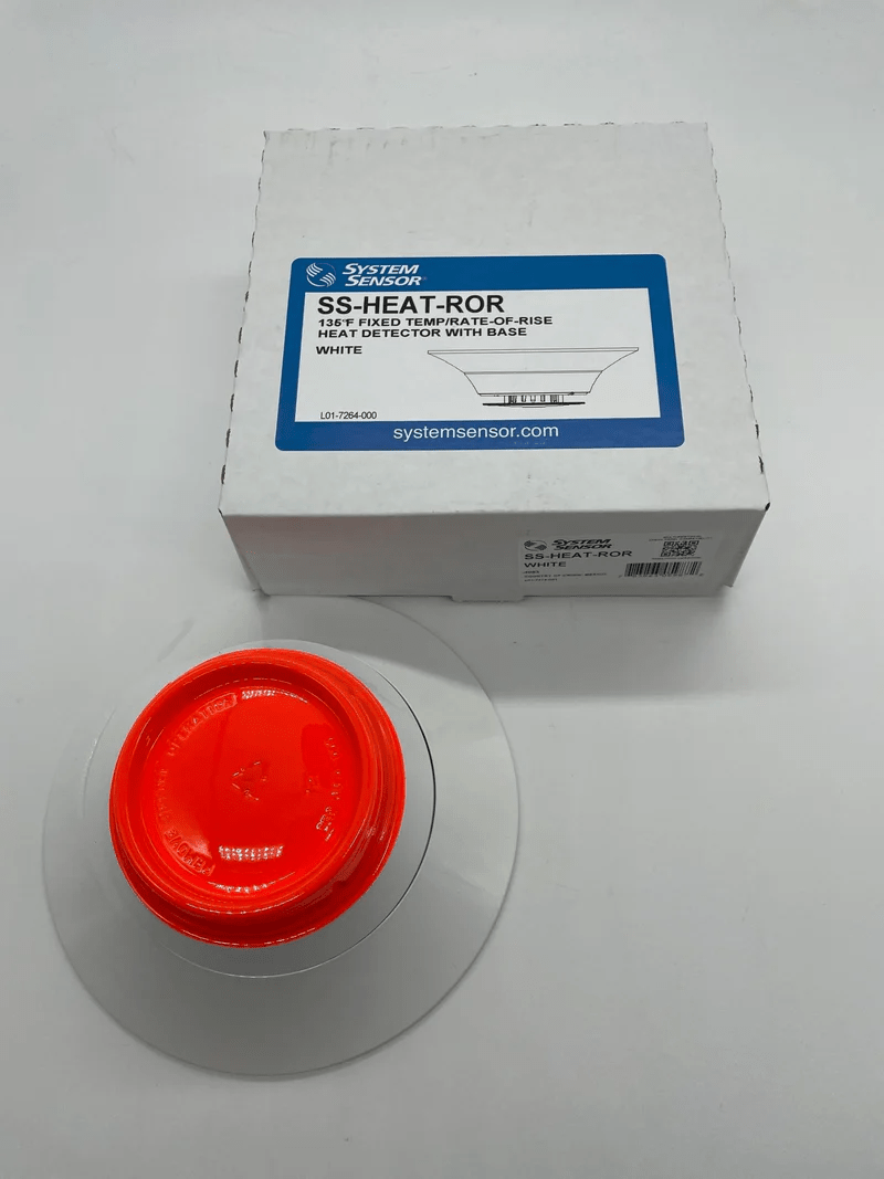 System Sensor SS-HEAT-ROR heat detector with reset feature, mounted on a ceiling, designed for fire safety systems.