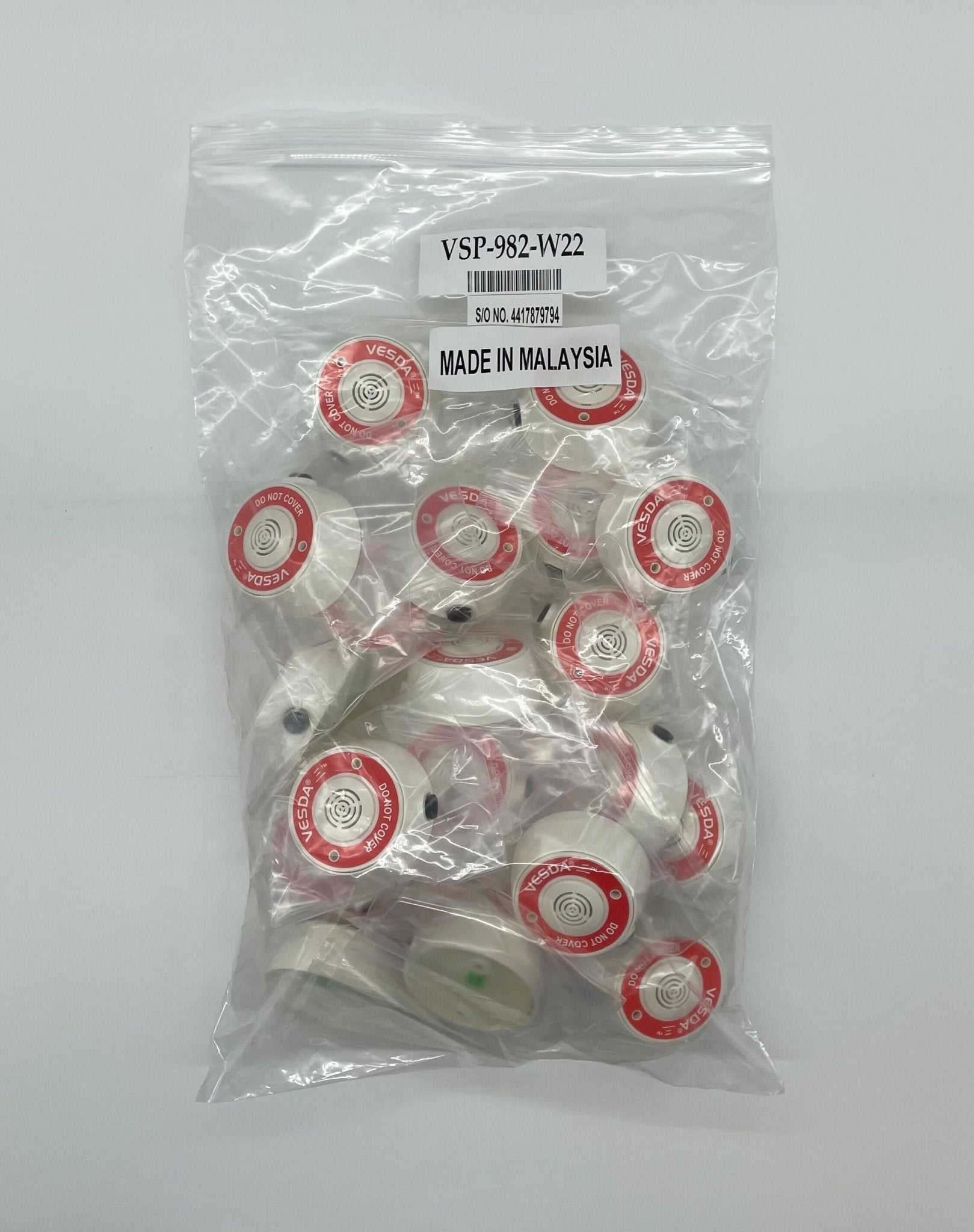 Vesda VSP-982-W22 fire alarm device, VESDA brand, mounted on wall with control panel and wiring visible.