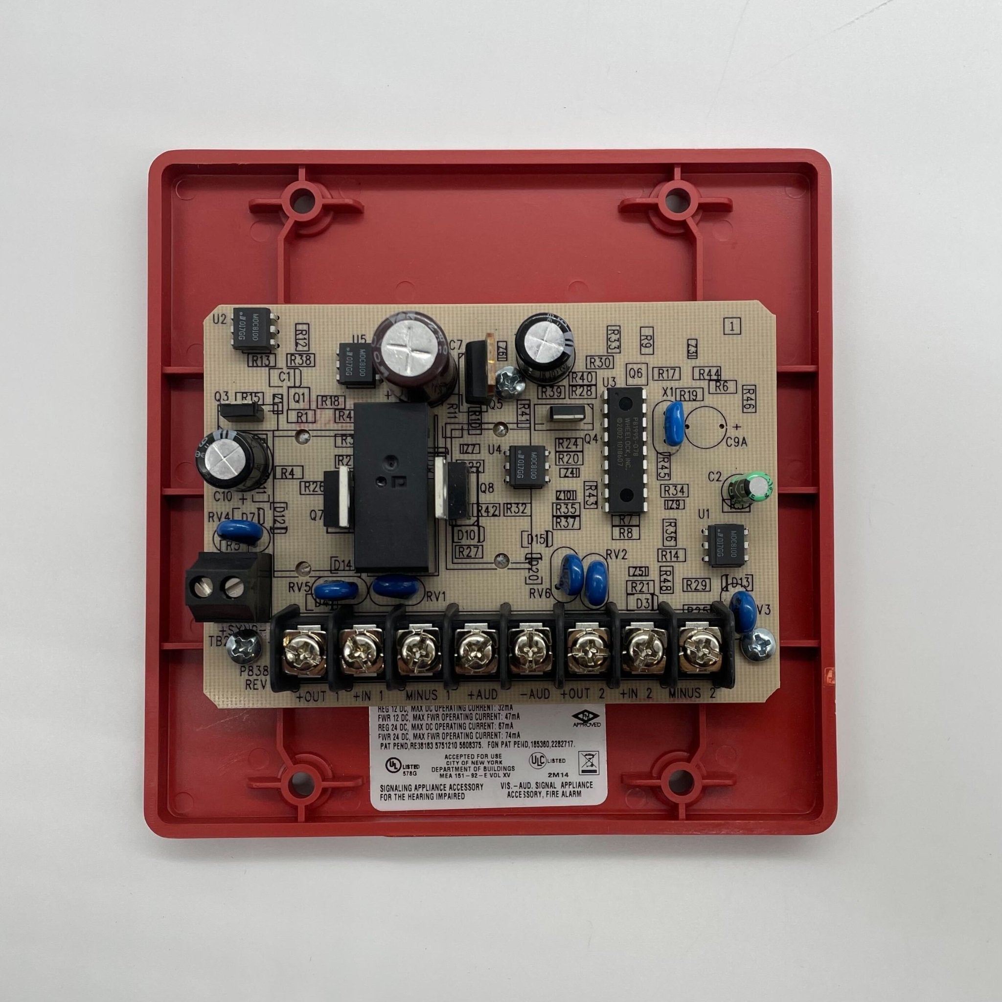 Eaton Wheelock DSM-12/24-R sync module showing front view with connection ports, used for fire alarm systems.