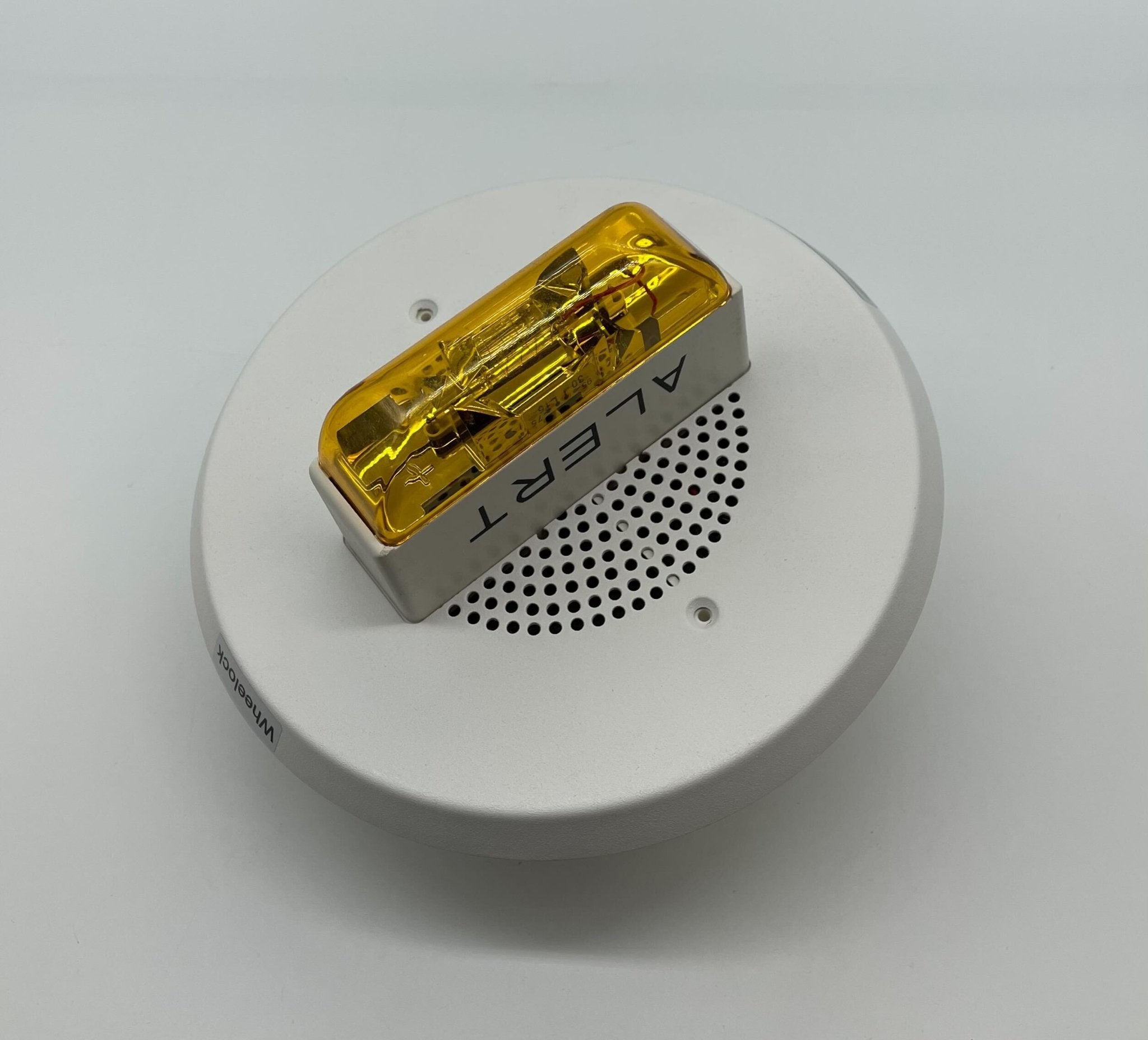 Eaton Wheelock E90A-24MCC-ALW speaker strobe with red housing and mounting bracket, designed for emergency notification systems.